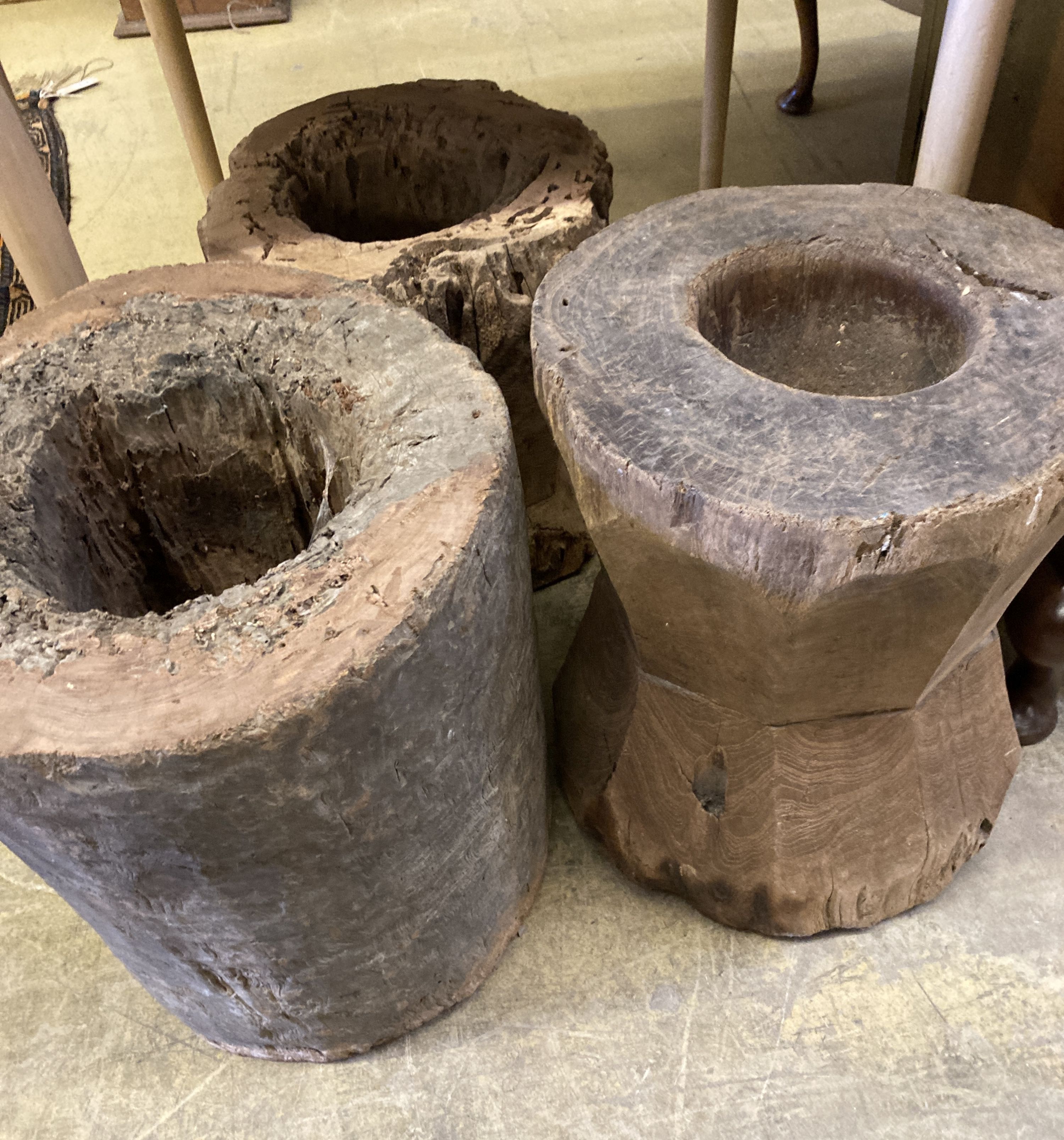 Three Indonesian hardwood rice mortars, largest 46cm high